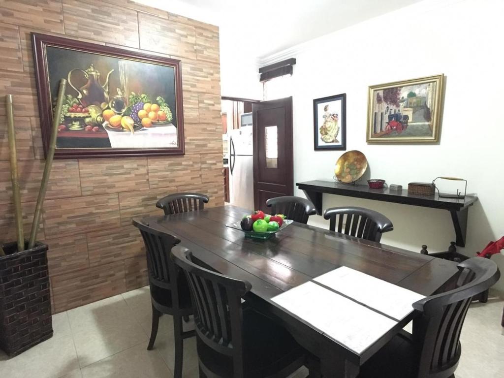 uma sala de jantar com uma mesa e um quadro na parede em Acogedor Departamento en El Gala em Santo Domingo