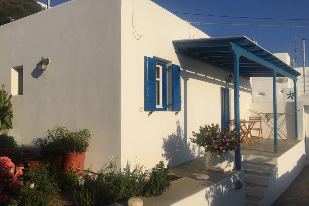 a white house with a blue door and a porch at Cycladic houses in rural surrounding 4 in Tholária