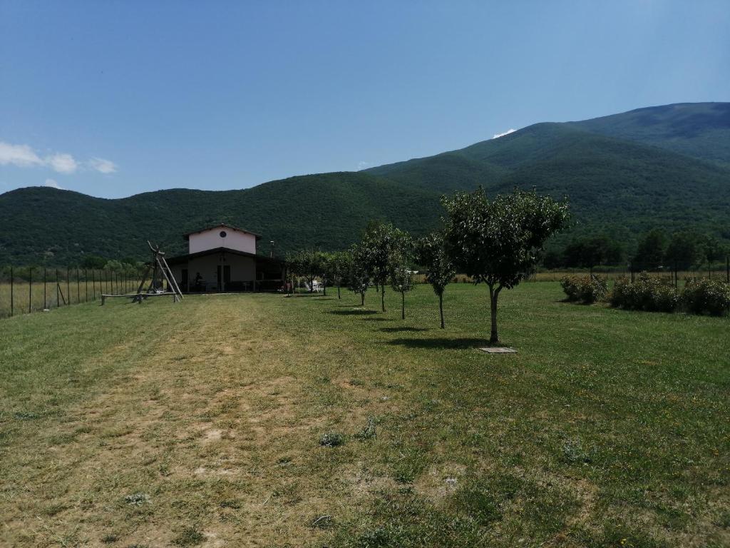 a field with trees in front of a building at Chalet Del Pozzo in Luco neʼ Marsi