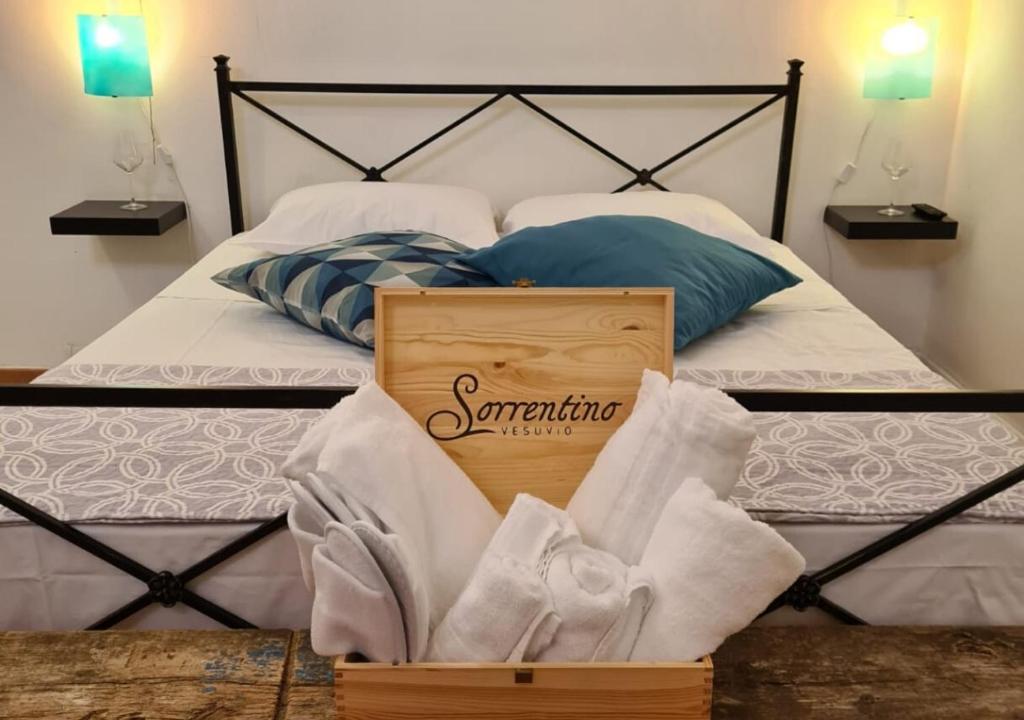 Una caja de toallas sentada en una cama en Vesuvio Inn Guest House e Wine Experience, en Boscotrecase