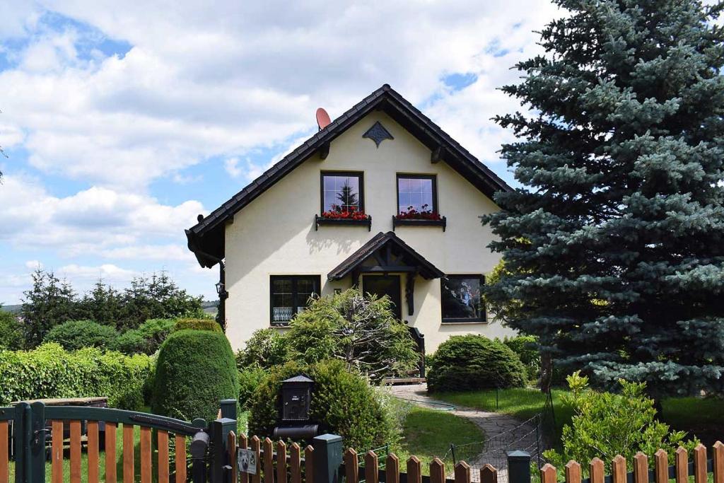 una casa blanca con dos ventanas y un árbol en Landhaus Kühn, en Bad Salzungen