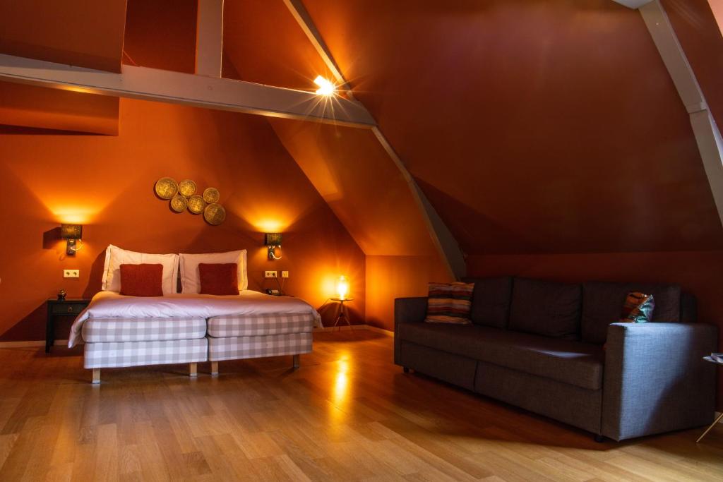 a bedroom with a bed and a couch in a attic at Hotel ML in Haarlem