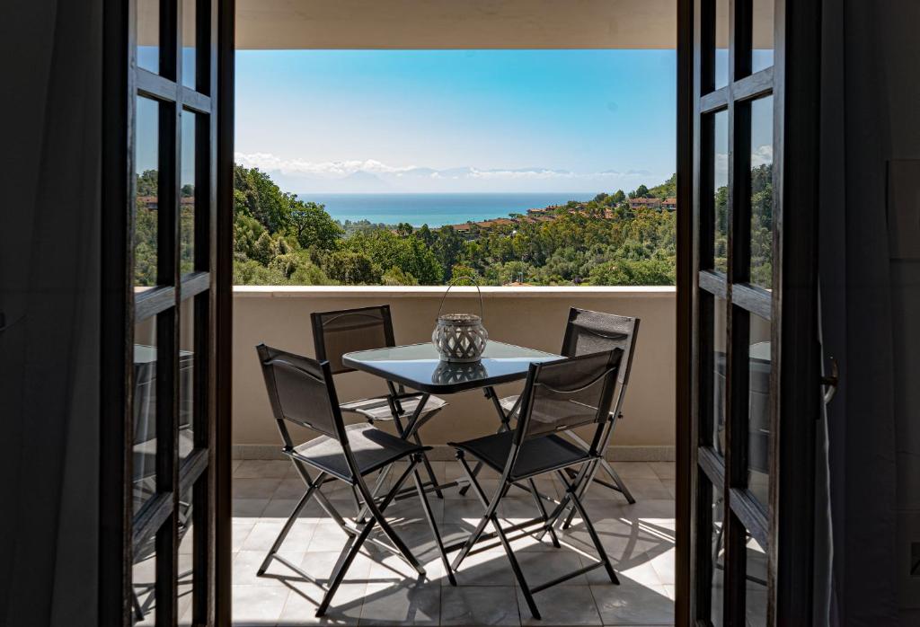 einen Tisch und Stühle auf einem Balkon mit Meerblick in der Unterkunft Casa vacanze Artemide in Scario