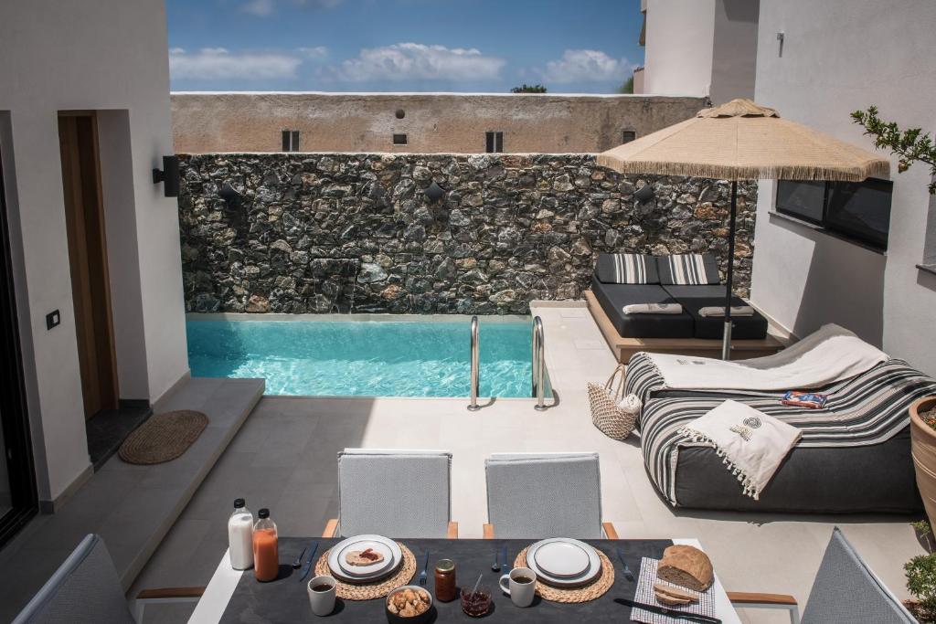 uitzicht op een patio met een zwembad bij Tarsia Homes & Suites in Kalamaki