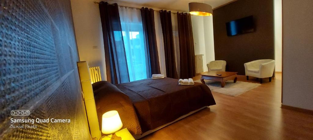 een slaapkamer met een groot bed en een woonkamer bij B&B Viviani Potenza in Potenza