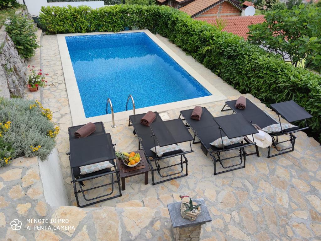 an overhead view of a swimming pool with lounge chairs and a pool at Apartment Gina in Opatija