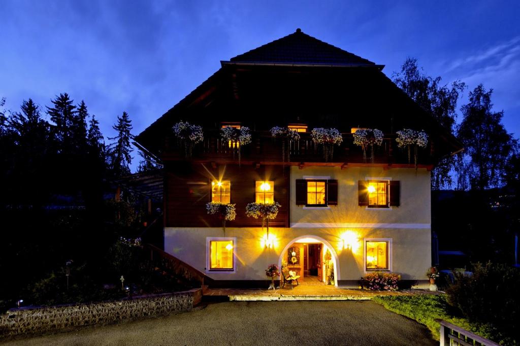 ein großes weißes Haus mit Balkon in der Nacht in der Unterkunft Gästehaus Biobauernhof Mandl in Murau