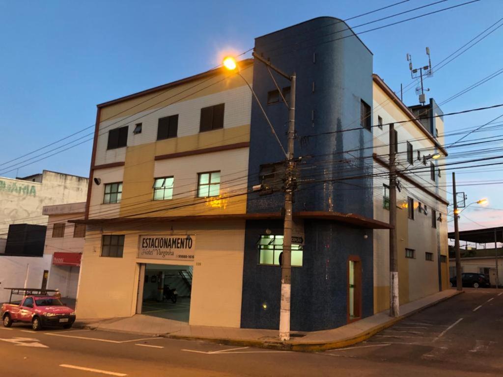 um edifício numa esquina com uma luz de rua em HOTEL VARGINHA em Varginha