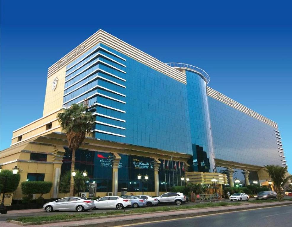 een groot gebouw met auto's geparkeerd voor het bij Casablanca Hotel Jeddah in Jeddah