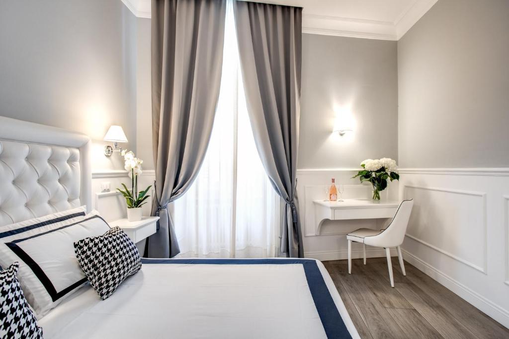 1 dormitorio con cama, escritorio y ventana en Just for us - Piazza di Spagna, en Roma
