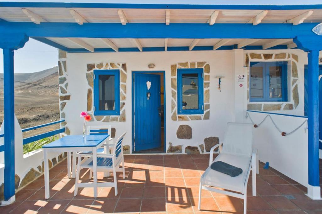プラヤ・ケマダにあるPuravida Playa Quemada 1の青いドア、テーブルと椅子付きのパティオ