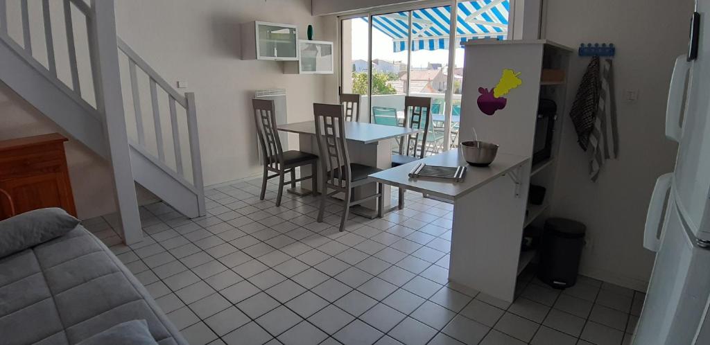 La cuisine est équipée d'un comptoir, d'une table et d'un réfrigérateur. dans l'établissement Appart 6 personnes, 3 min à pied de la plage et du centre ville, à Saint-Georges-de-Didonne