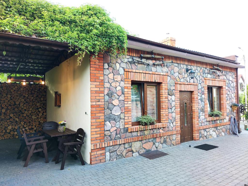 a brick building with a table and chairs in front of it at Pokoje Gościnne Majka in Mrągowo