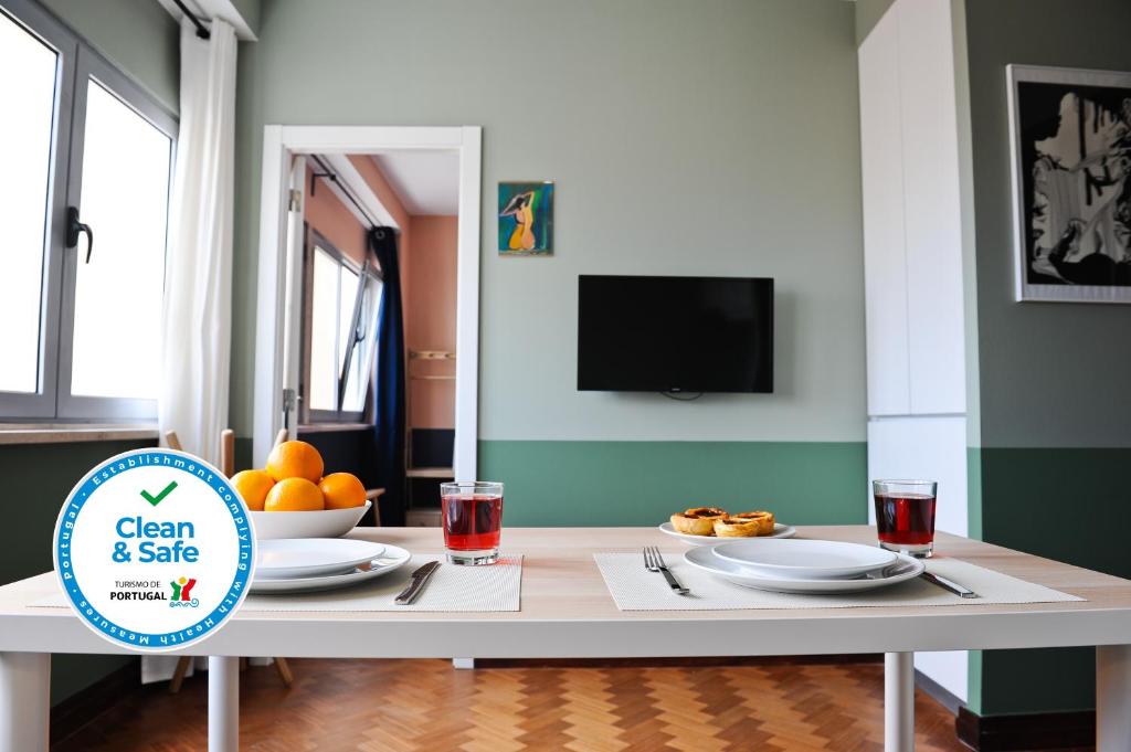 a dining room table with plates of food and a tv at Mojito by the River Apartment 3C in Lisbon