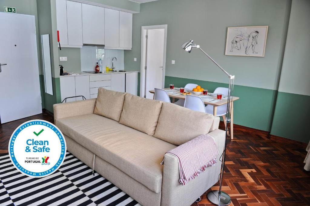 a living room with a couch and a kitchen at Gin o clock Apartment 3A in Lisbon