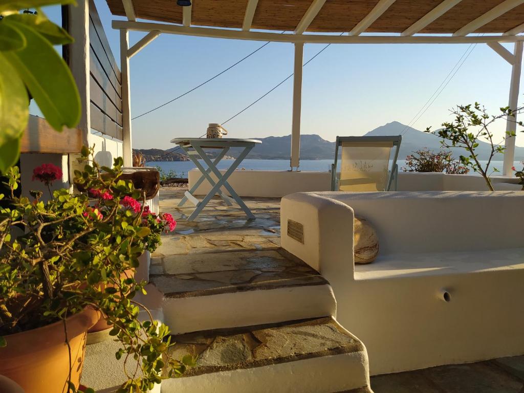 un portico con letto, tavolo e fiori di Waves House ad Adámas
