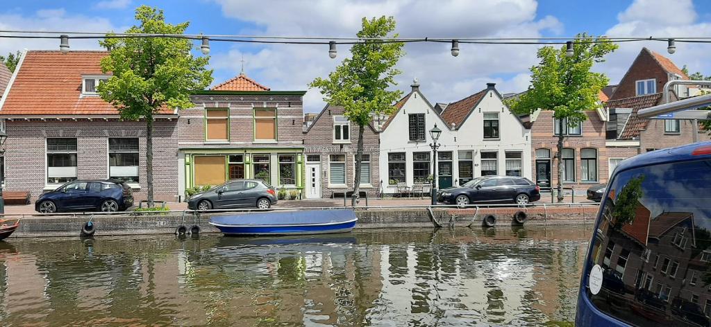 een blauwe boot in het water naast gebouwen bij Oudegracht Alkmaar in Alkmaar