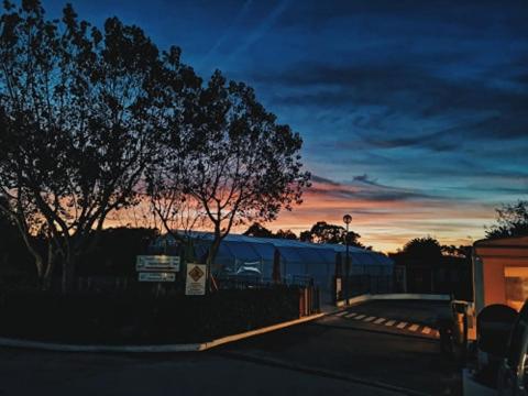 a train is parked next to a fence at sunset at Camping Villa Park Zambujeira do Mar in Zambujeira do Mar