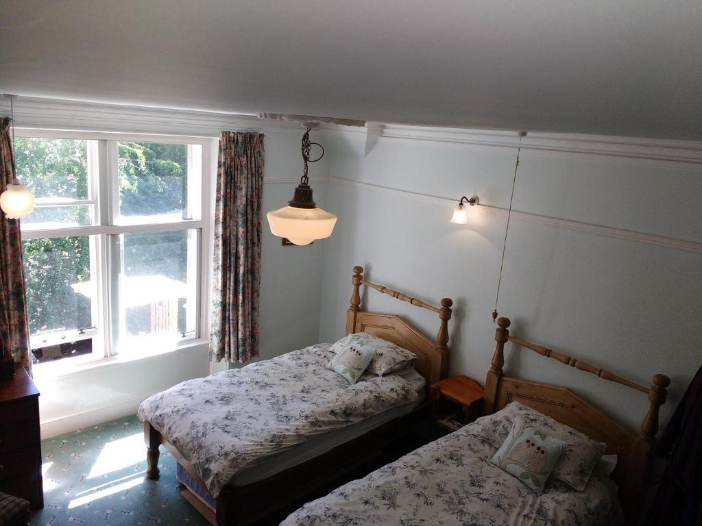 a bedroom with two beds and a window at Greystones B&B in Kingussie