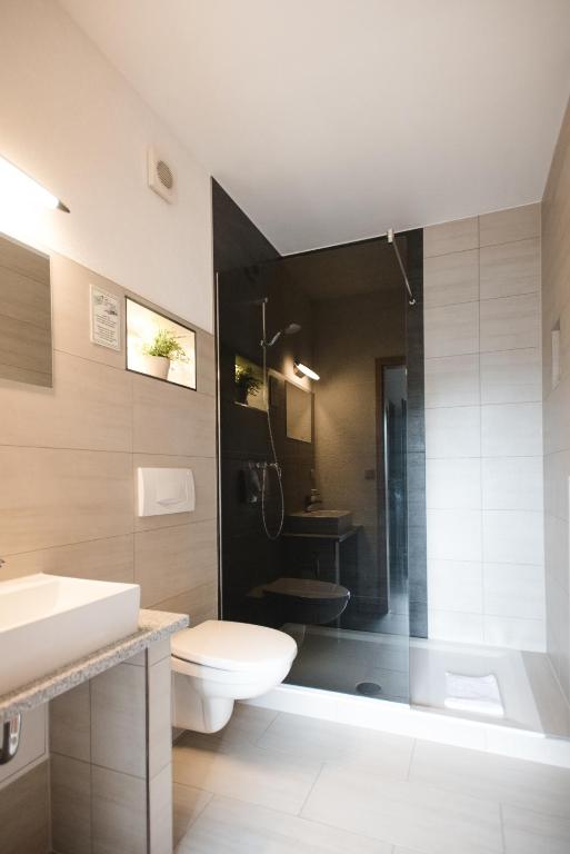 Un baño con inodoro, lavabo y ducha. en Toschis Station-Motel-Wirtshaus-an der Autobahn-Bowling, en Zella-Mehlis