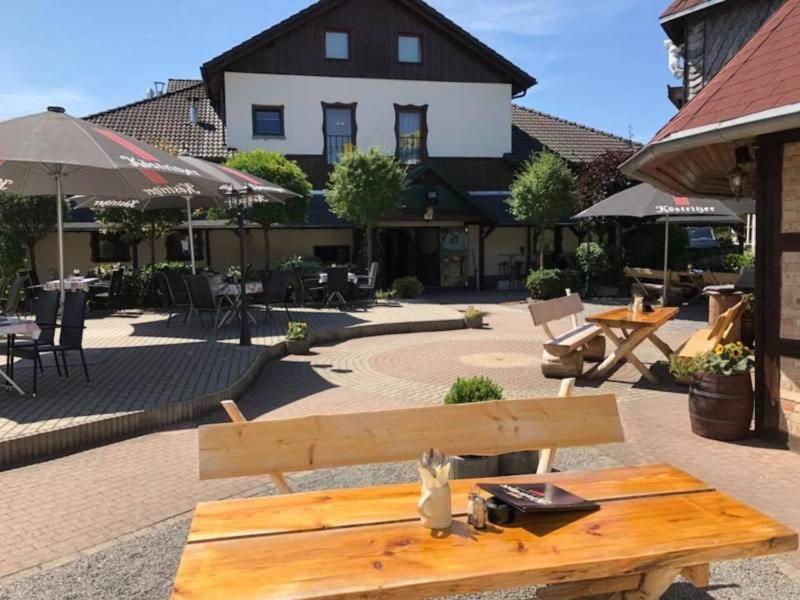 a wooden bench sitting in front of a building at Toschis Station-Motel-Wirtshaus-an der Autobahn-Bowling in Zella-Mehlis