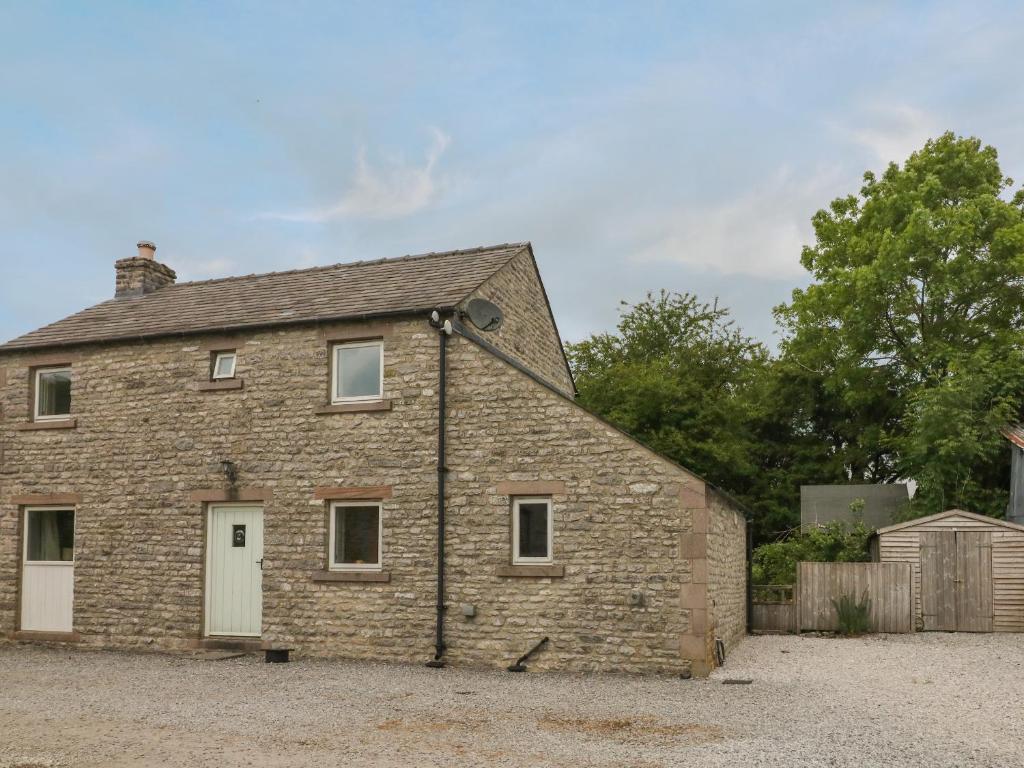 an old brick building with a white door at Limers Cottage in Buxton