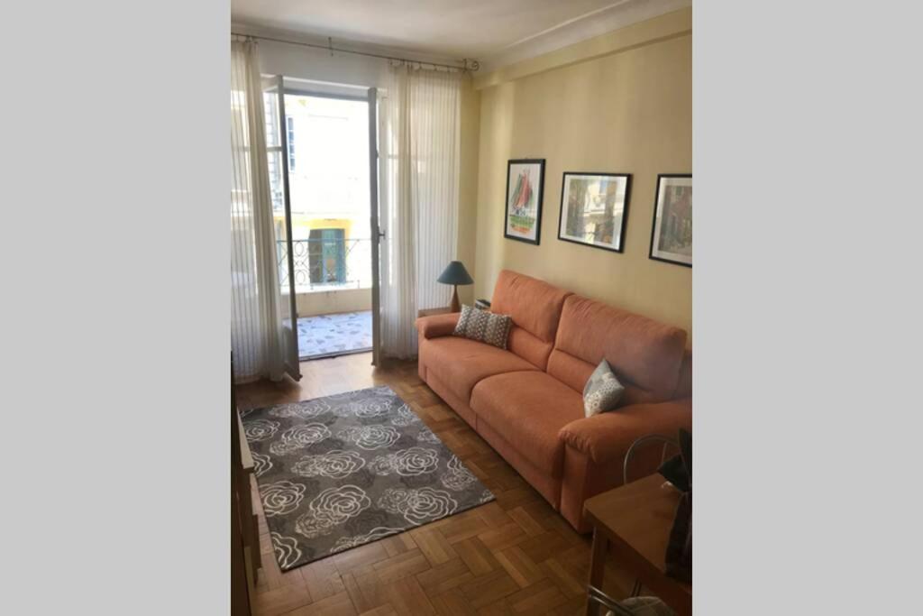 ein Wohnzimmer mit einem Sofa und einem Fenster in der Unterkunft Joli 2 pièces à 150m de la plage in Nizza