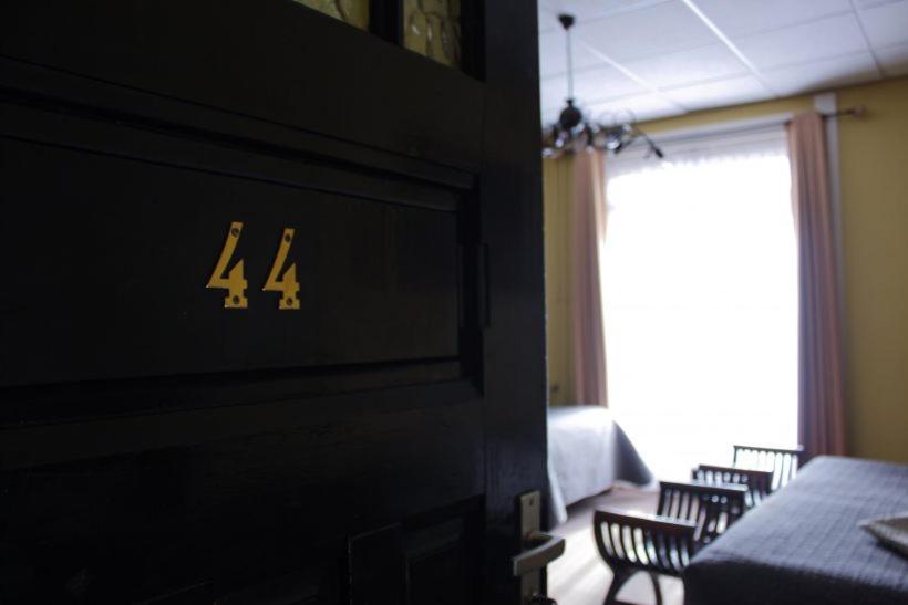 een kamer met een tafel en stoelen en een muur met een klok bij Hotel Eethuys de Wormshoef in Lunteren