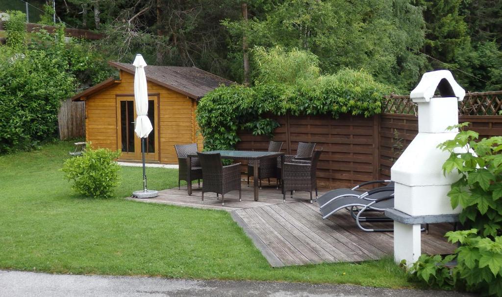 una terrazza in legno con tavolo e sedie in un cortile posteriore di Landhaus Relly a Seefeld in Tirol