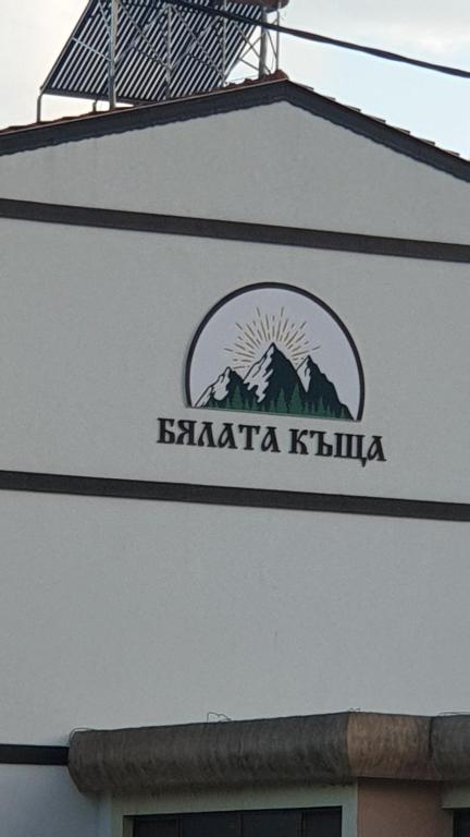 um sinal na lateral de um edifício em БЯЛАТА КЪЩА em Kirkovo