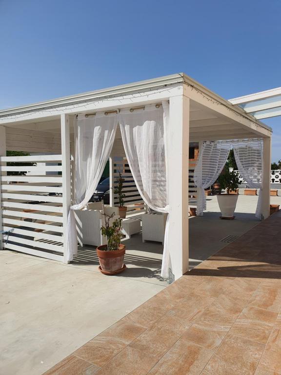 biała pergola z białymi zasłonami na patio w obiekcie Luxury CASELLO 28 Affitti Brevi w mieście Marconia