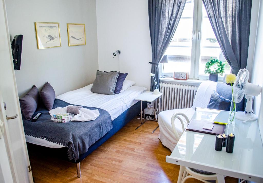 um pequeno quarto com uma cama e uma mesa em Park Hotell em Örnsköldsvik