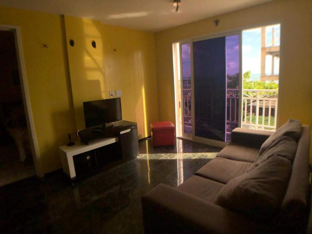 a living room with a couch and a tv at Apartamento Mobiliado Vila Iracema in Fortaleza