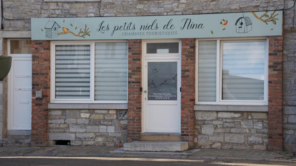 un edificio de ladrillo con una puerta y ventanas blancas en Les petits nids de Nina 1 en Fosses-La-Ville