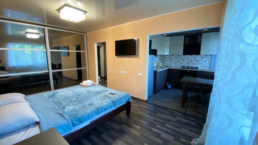 a bedroom with a bed and a sink and a mirror at Apartment in the center in Zhytomyr