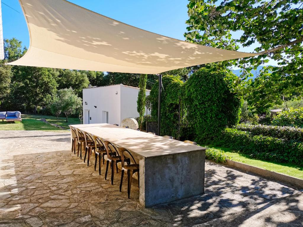 einen Tisch mit Stühlen unter einem weißen Schirm in der Unterkunft Maison San Giovanni in Corte