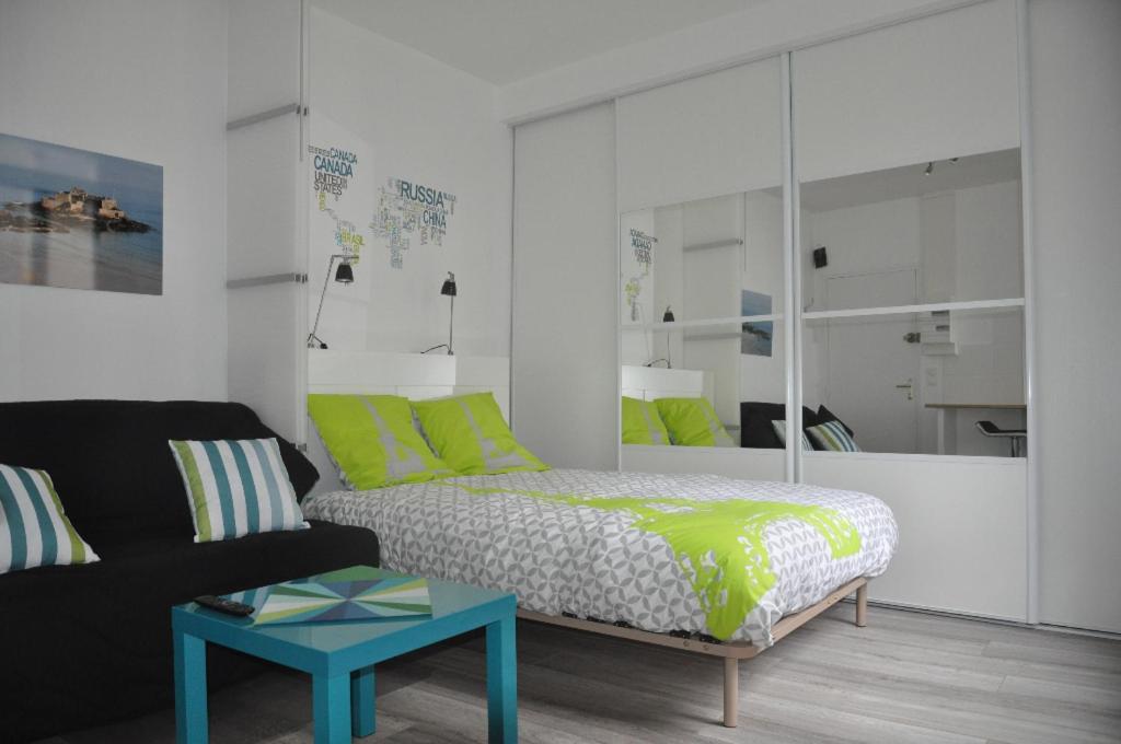 une chambre avec un lit, un canapé et une table dans l'établissement Studio lumineux Intra-muros à 2 pas de la plage., à Saint-Malo