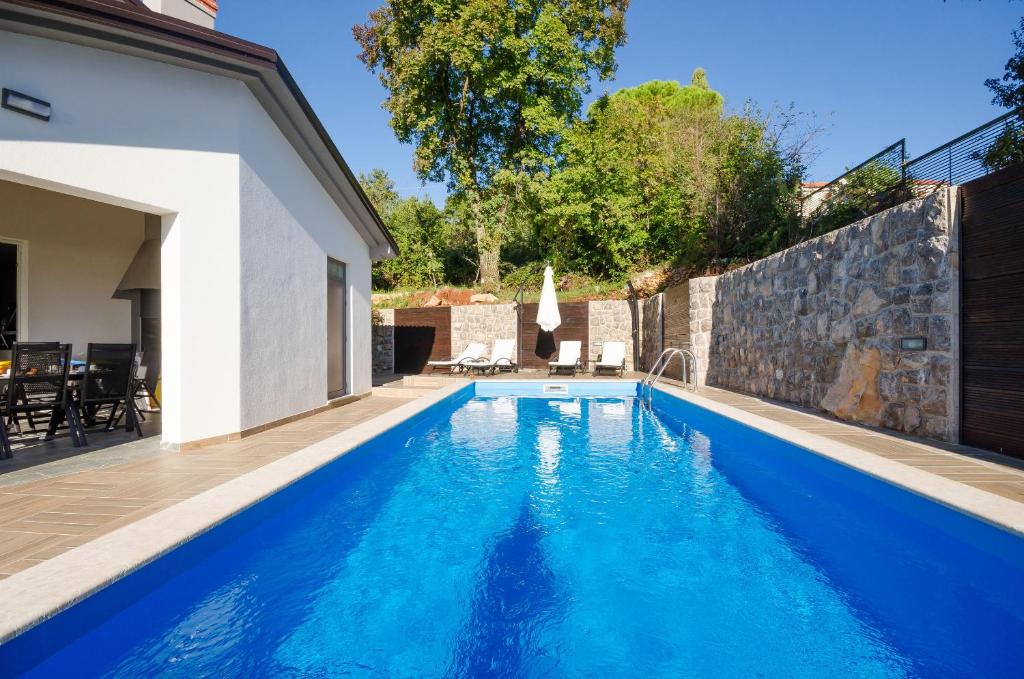 a swimming pool in the backyard of a house at Villa Icici in Ičići