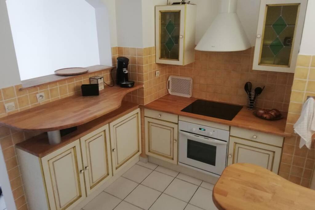 a kitchen with wooden cabinets and a counter top at T2 CARRY LE ROUET CENTRE VILLE PROCHE DE LA MER in Carry-le-Rouet