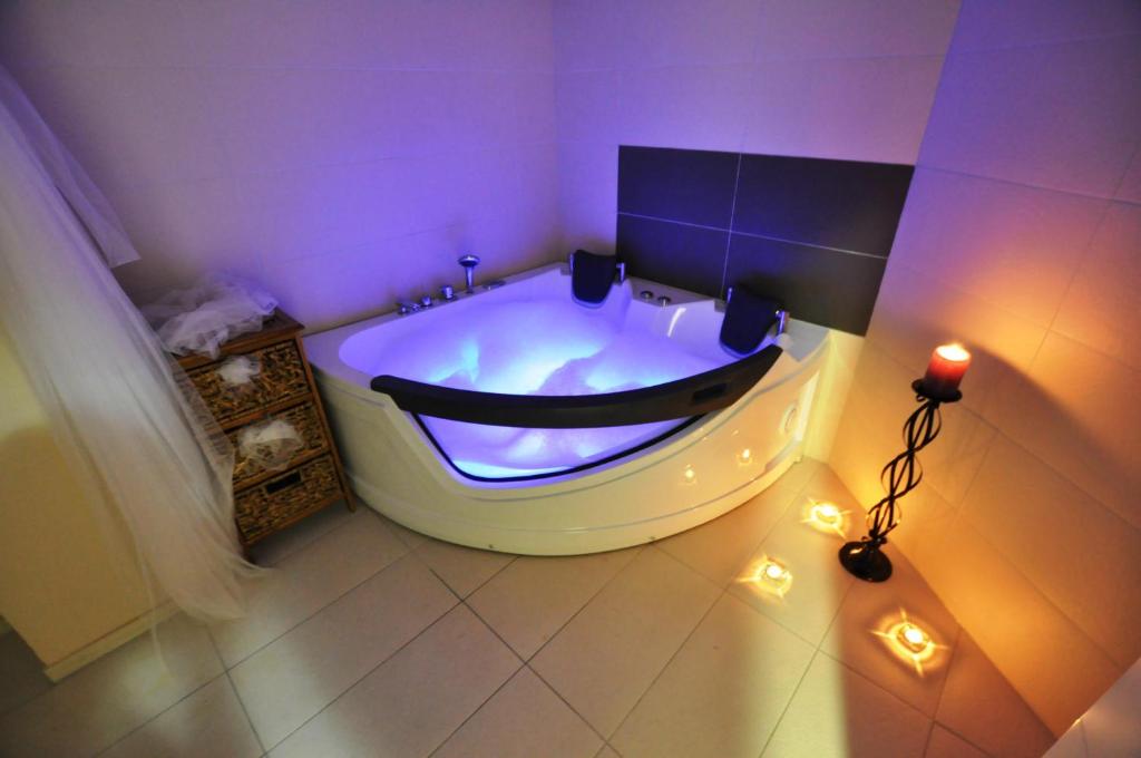 a bathroom with a large tub with lights in it at Hotel Royal Spa in Banja Koviljača
