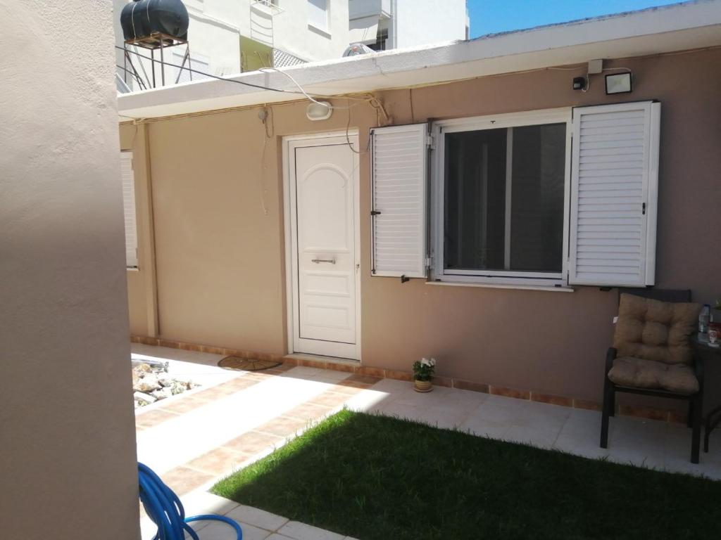 una stanza con una porta, una sedia e una finestra di Nikoleta Apartment a Chania