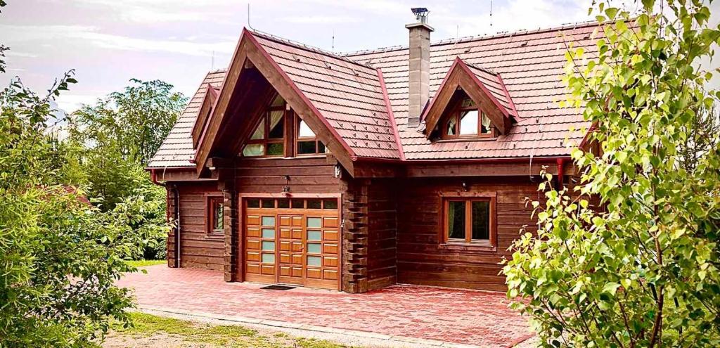 een houten huis met een gambrel dak bij ZRUB BINDT in Hnilčík