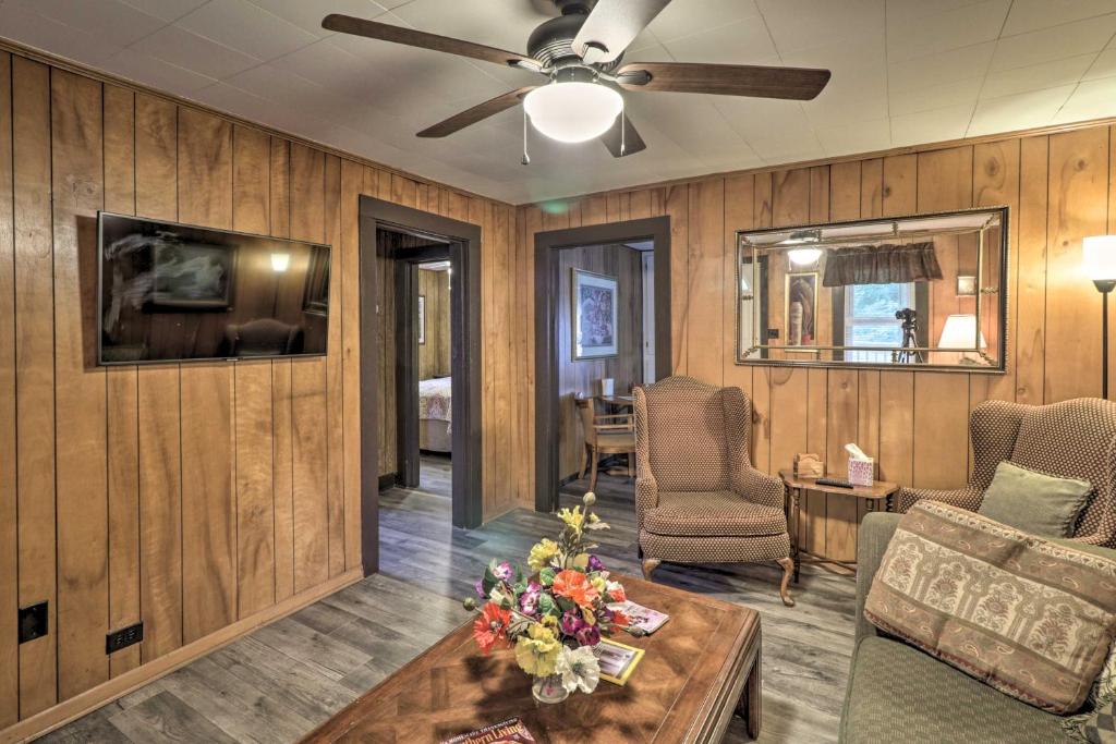 a living room with wooden walls and a ceiling fan at Hot Springs Home Less Than 1 Mi to Oaklawn Racing Casino! in Hot Springs