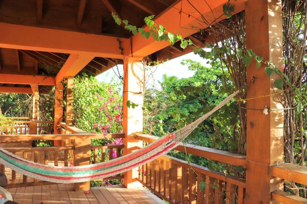 a hammock on the porch of a house at Hotel Posada Seremein Roatan in West Bay