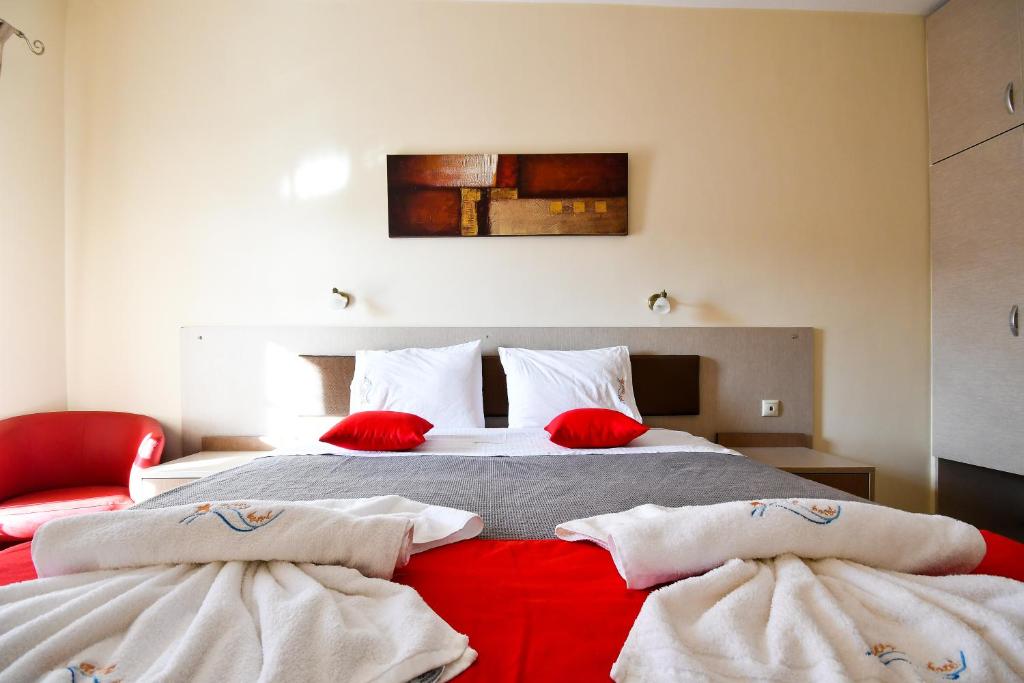 a bed room with two beds and two lamps at Avra Hotel in Ormos Panagias