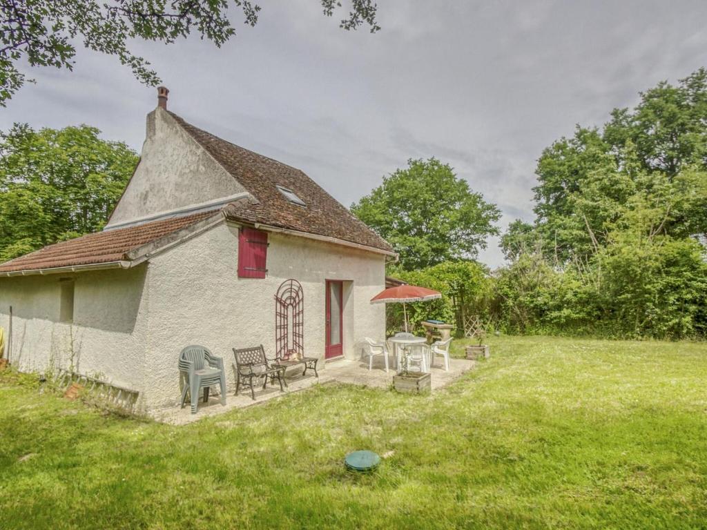 an old house with chairs and tables in a yard at Country house near Canal du Nivernais in Devay