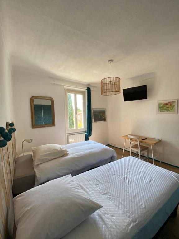 um quarto com 2 camas, uma mesa e uma janela em Ocra Pure em Roussillon