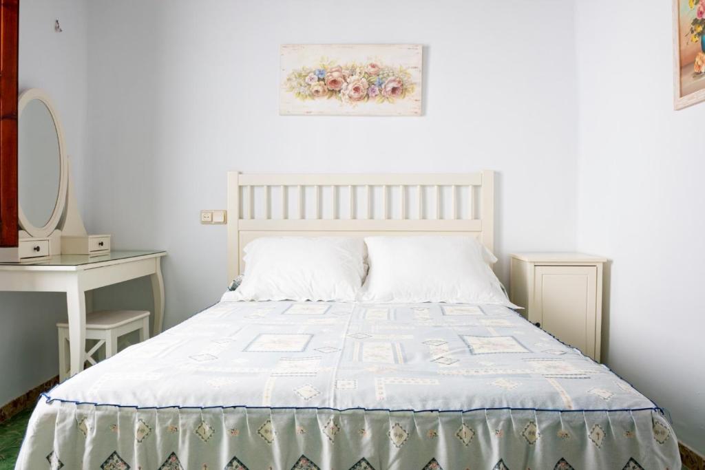 ein weißes Schlafzimmer mit einem Bett und einem Tisch in der Unterkunft Casa Boutique Margarita in Peñíscola
