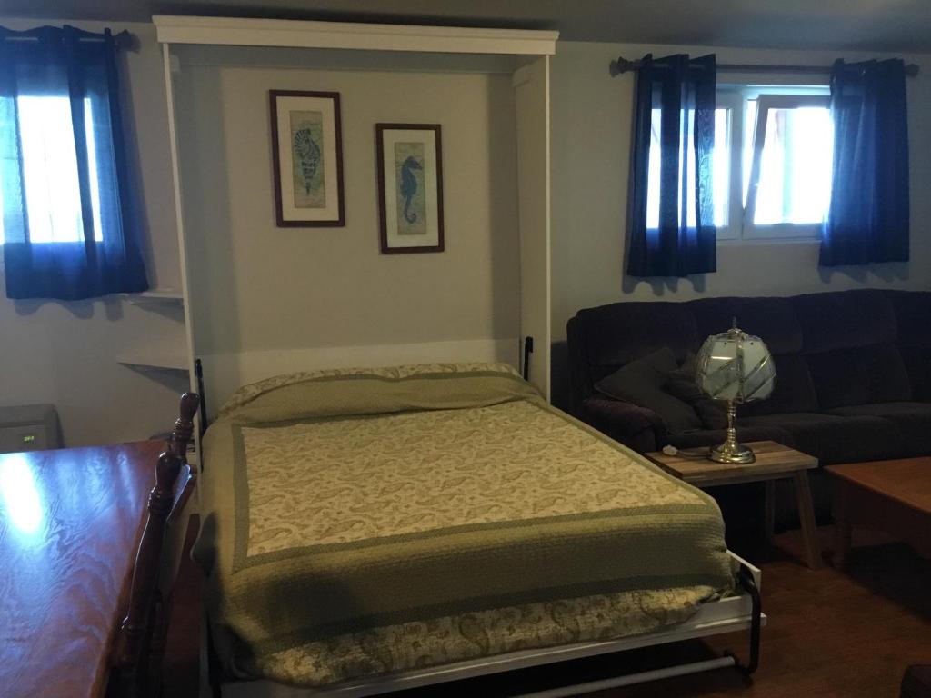 a bedroom with a bed and a couch at BeachView Apartment in Port Hood