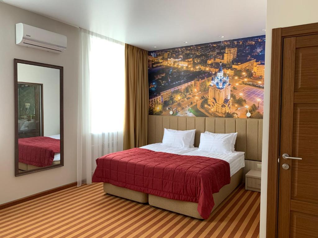 ハバロフスクにあるHotel Khabarovskのベッド付きの客室で、壁には絵画が飾られています。